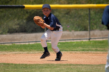 Little League Baseball Infielder Fielding A Ground Ball