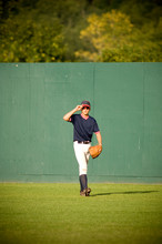 Young Outfielder Adjusting His Sunglasses On Baseball Field