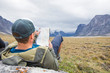 © Cavan Images - Climber reading map guide, directions to next mountain.
