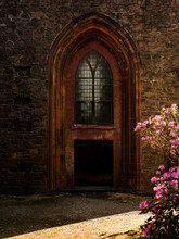Church Door With A Rhododendron Bush In Front