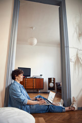 Wall Mural - Handsome stylish guy using laptop at home