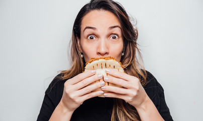 Wall Mural - Portrait of girl eating an arepa of shredded meat. Typical Latin American food