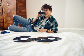 Wall Mural - Attractive young man taking photo with vintage camera