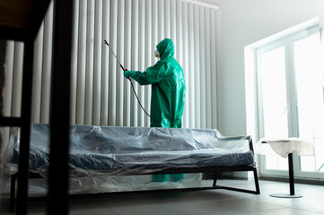 Wall Mural - Chemical worker sanitizing the wall with chlorine spray stock photo