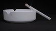 smoldering cigarette in an ashtray on a black background