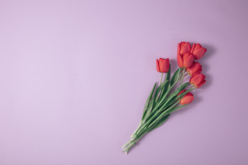 Bouquet of fresh spring tulips on the table with space top view. Spring pink vintage background.