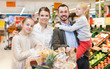 © JackF - Man with wife and children holding purchases in supermarket