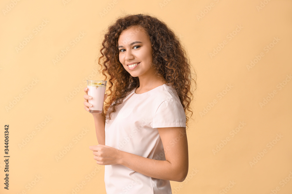 Young woman with tasty yogurt on color background