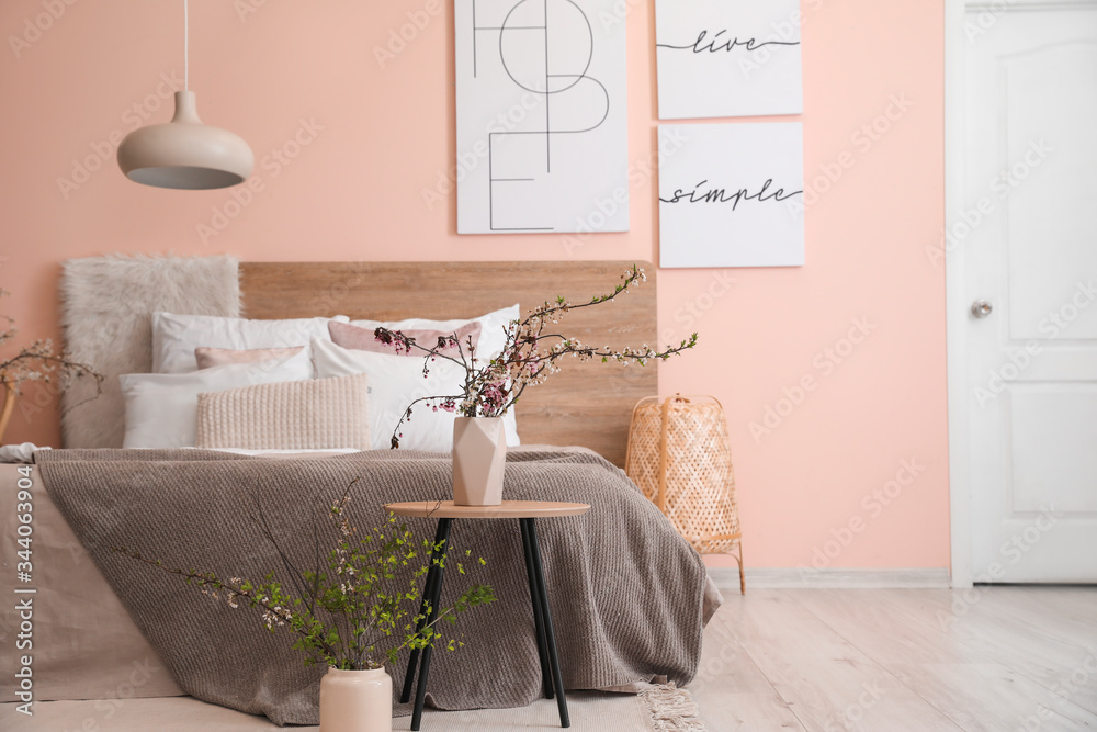 Interior of beautiful modern bedroom with spring flowers