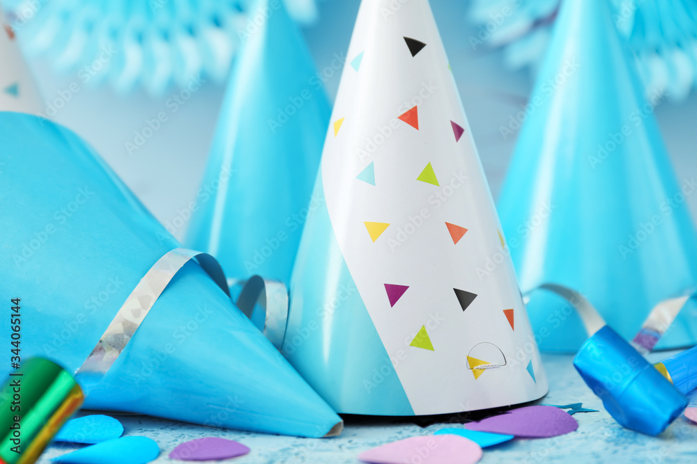 Party hats and decor on color background