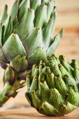 Wall Mural - Fresh artichokes on a rustic wooden background