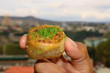 Closeup a Pistachio Baklava Pastry in Hand with Blurry View in Background
