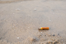 Cigarette Butts In The Sand On Beach.