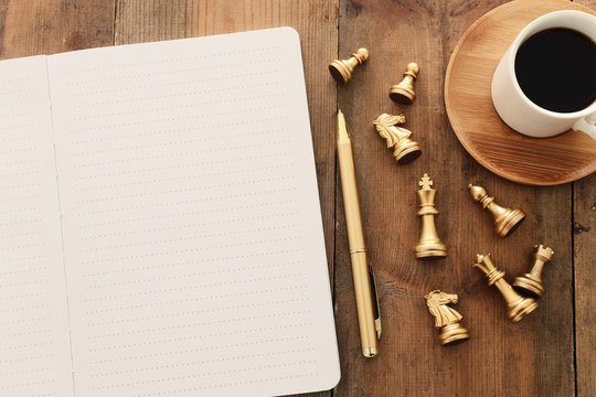 top view image of open notebook with blank pages next to cup of coffee on wooden table. ready for adding text or mockup