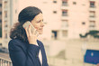 © Mangostar - Serious businesswoman talking by smartphone. Focused middle aged businesswoman talking via cell phone and working with documents on street. Business concept