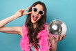 © Drobot Dean - Photo of joyful woman gesturing peace sign while posing with disco ball