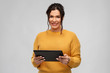 technology and people concept - happy woman using tablet computer over grey background