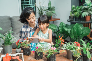 Wall Mural - mother and daughter gardening and studying activity at home together