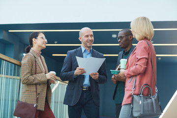 Sticker - Mature businessman holding documents and giving recommendation for his team at office