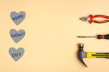 Sticker - Flat lay with hammer, screwdriver, pliers and paper hearts with lettering happy fathers day on beige background