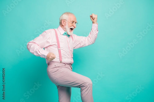 Profile photo of funny crazy excited hipster grandpa raise fists up celebrating money income wear specs pink shirt suspenders bow tie pants isolated teal color background