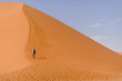 Mann wandert auf Düne, Namibia