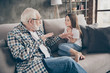 Photo of funny two people old grandpa little granddaughter sitting comfort sofa telling good story stay house quarantine safety modern design interior living room indoors
