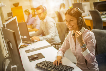 Friendly Call center smiling operator woman with phone headset. Business, communication, technology and call center concept.