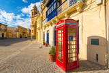 Fototapeta  - Red phone both on the street of Marsaxlokk village on Malta