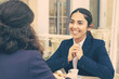 © Mangostar - Smiling businesswomen talking and drinking coffee. Professional female coworkers in formal wear sitting at table and drinking coffee together in outdoor cafe. Coffee time concept