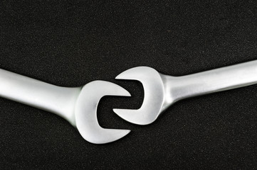 Two chrome-plated spanner. Isolated on a black relief background.