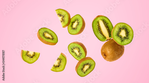 Photographie Fresh kiwi fruit flying in air on pink