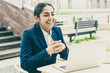 © Mangostar - Happy businesswoman using laptop in cafe. Cheerful young businesswoman sitting at table and using laptop computer in outdoor cafe. Business and technology concept