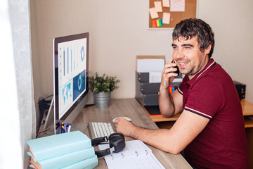 A modern young person works remotely from home. Young man video conference via computer. Home office. Stay at home and work from home concept during the coronavirus pandemic