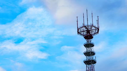 Close-up big television and radio tower on the classic blue sky background. Space for text.