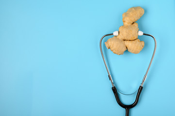 .Natural medicine. Immunostimulating products: ginger root. Ginger and stethoscope on a blue background, the concept of healthy immunity.