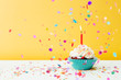 Birthday cupcake wih confetti on yellow background