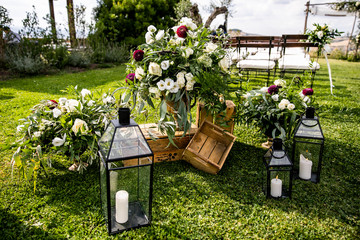 in backyard of villa in Tuscany there is banquet wooden table decorated with cotton and eucalyptus compositions, glasses, candles and plates are placed on table