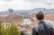 Mann mit Stadt im Hintergrund Ansicht von hinten Lederjacke Überblick Tourismus