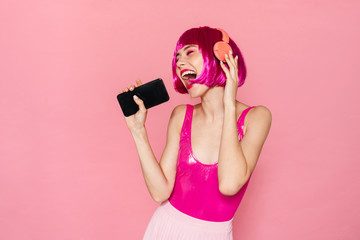 Sticker - Image of excited pretty woman in headphone singing and using cellphone