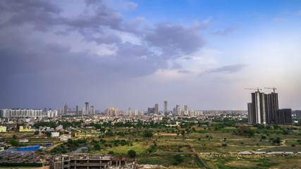 Wall Mural - Aerial timelapse shot monsoon clouds over feilds, slums, skyscrapers with residences and offices in the distance