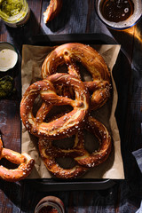 Wall Mural - Oktoberfest food menu, soft pretzels and beer on wooden background copy space top view.