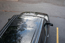 Raindrops Falling On The Roof Of Black SUV Car On Parking