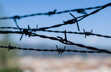 Closeup of a barbed wire against blue sky