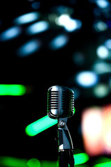 Karaoke background.Silver vintage microphone on bokeh.Close-up of retro microphone at concert.Professional microphone
