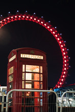 Typical English Red Phone Booth At Night With London Eye In The Background