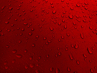 Drops of water on a red metal surface, beautiful background after rain