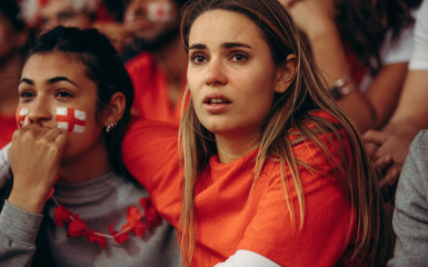 English soccer fans anxiously watching a game from stadium