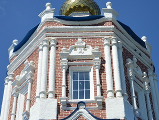 Wall Mural - A tower of an ancient baroque orthodox church in Solotcha convent in Russia, white columns, a golden dome, a decorated window, a colorful sight, on a sunny day