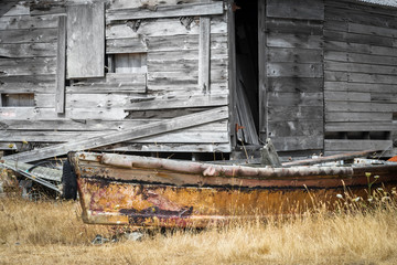 A retired fishing boat rests beside a weather boat shack on Lummi Island, Washington State.